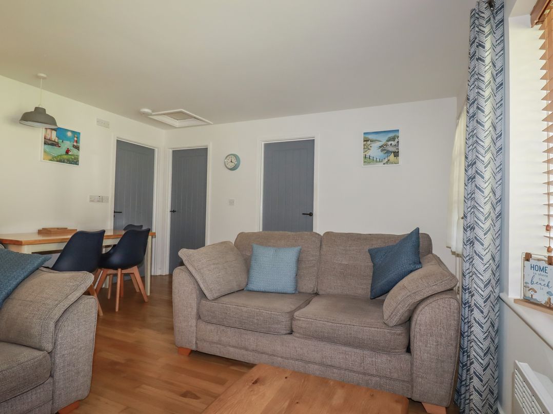 A living room with a sofa and dining table at Lilyvale Davidstow near Camelford