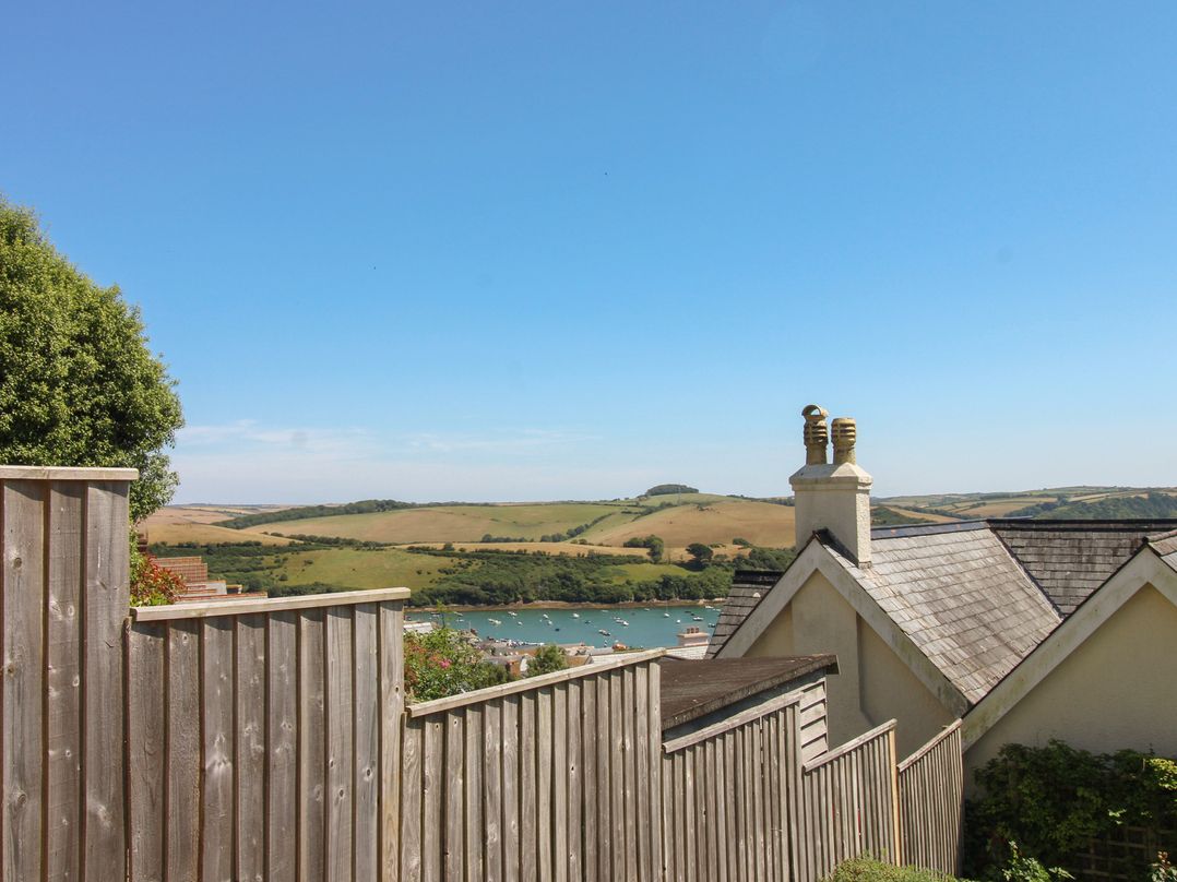 A view of a landscape with a house and water in the foreground at Waders in Salcombe