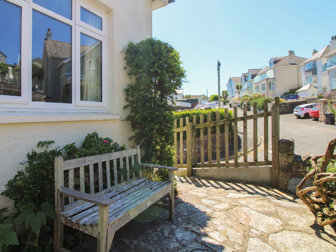 An outdoor space with a bench and gate at Waders in Salcombe