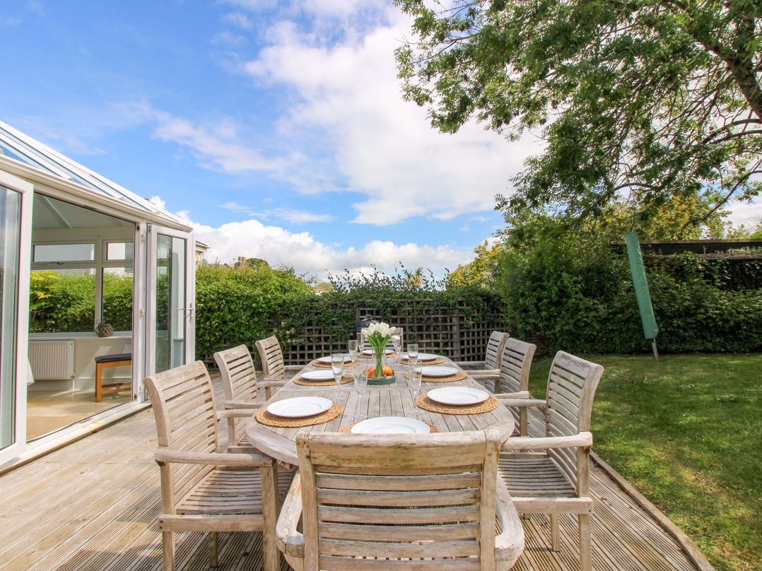 A garden with an outdoor dining table and chairs at Welsummer Salcombe