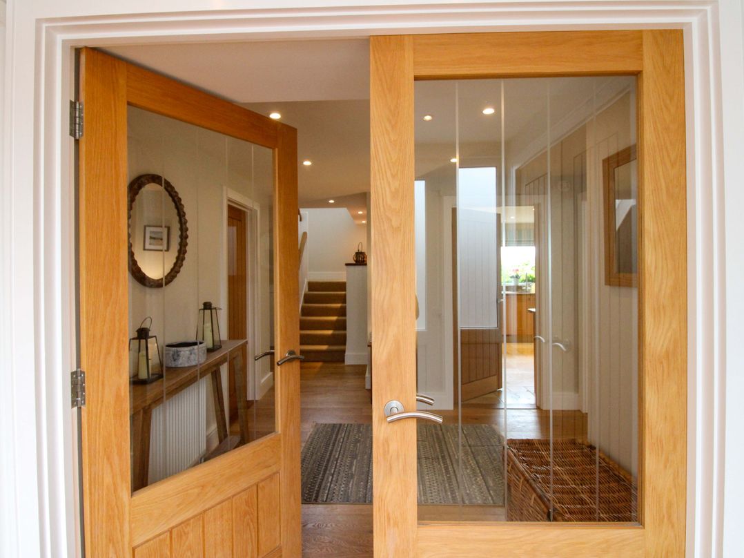 An entrance hall with double doors and a console table at Welsummer Salcombe