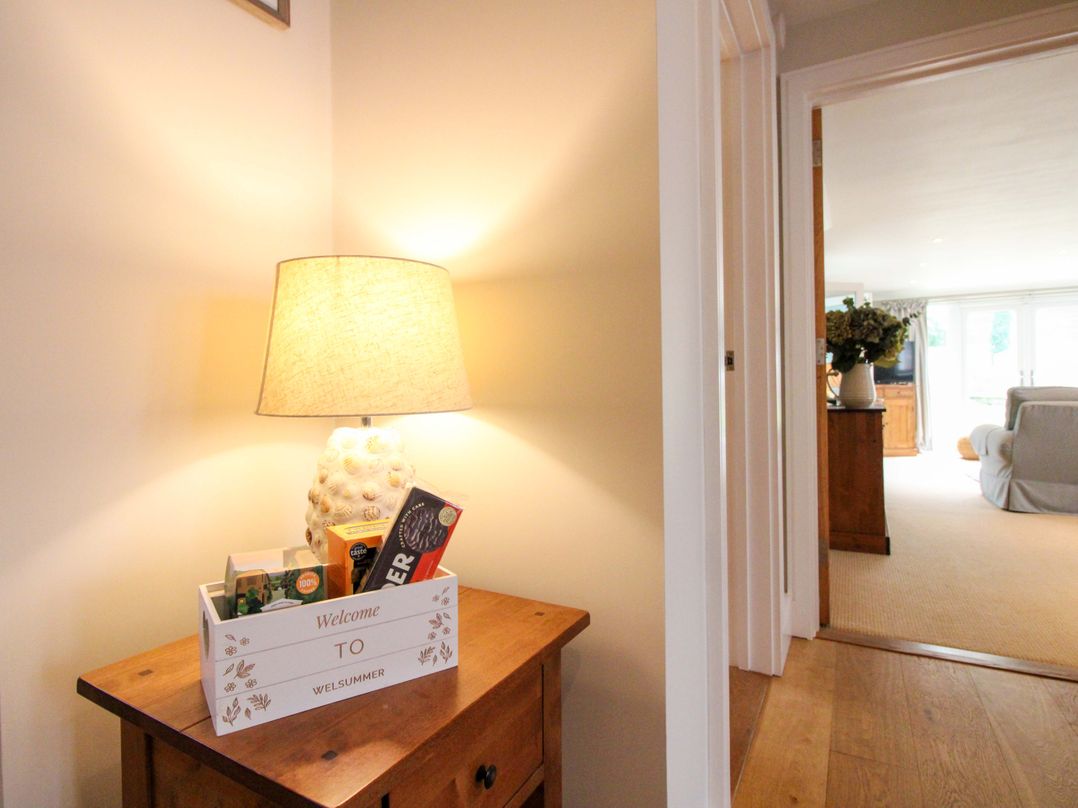 A hallway with a lamp and a welcome basket at Welsummer in Salcombe