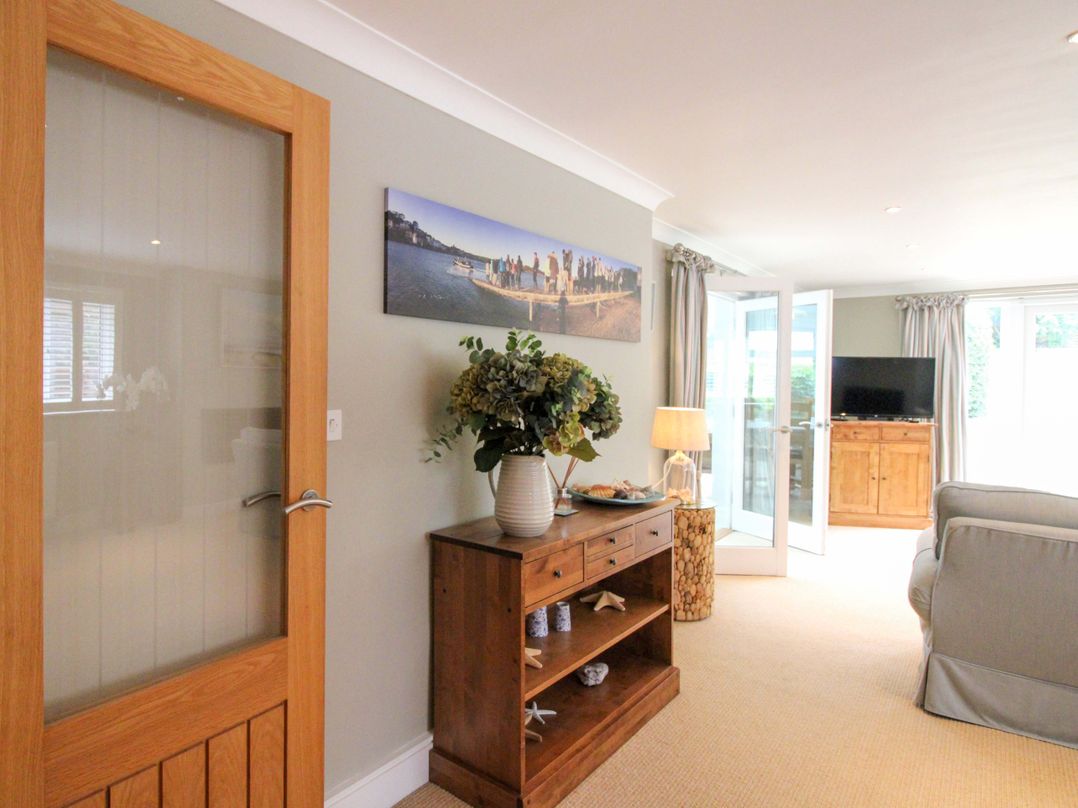 A living room with furniture and a television at Welsummer in Salcombe