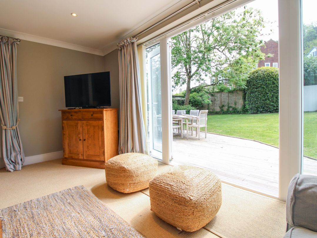 A living room with a television and sliding doors at Welsummer in Salcombe