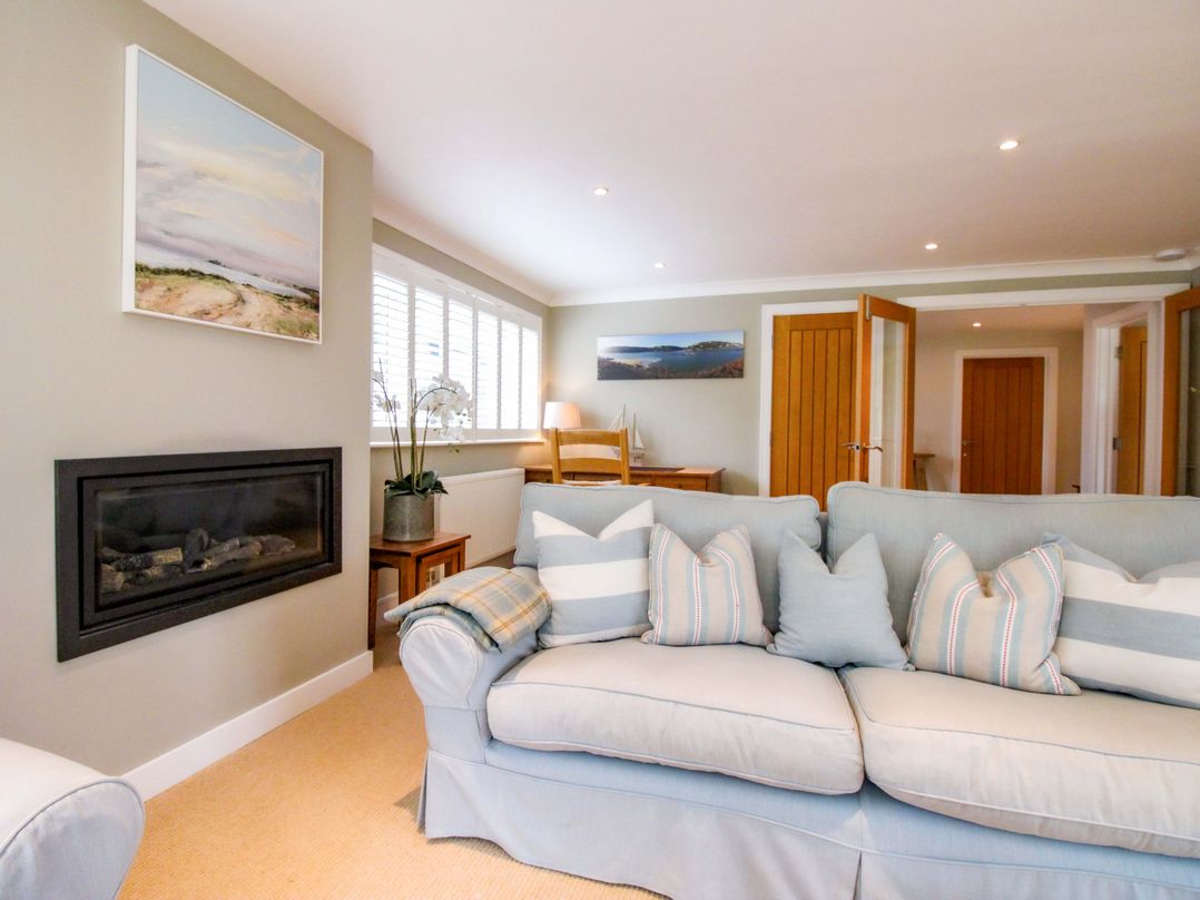 A living room with a sofa and fireplace at Welsummer in Salcombe
