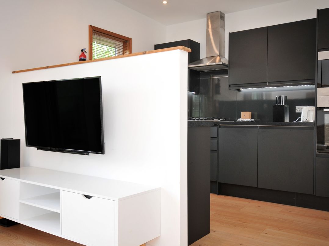 A kitchen with a television and kitchen cabinets at 12 Meadow Retreat in Dobwalls