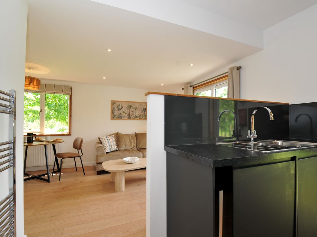 A kitchen with a sink and living area at 12 Meadow Retreat in Dobwalls
