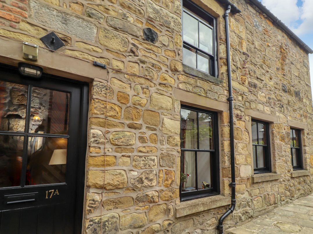An exterior wall of a stone house with windows and a door at Lavender Cottage (Bailiffgate) Alnwick