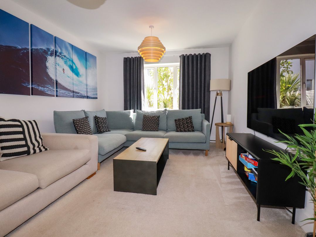 A living room with a sofa and television at Lavender House in Crantock