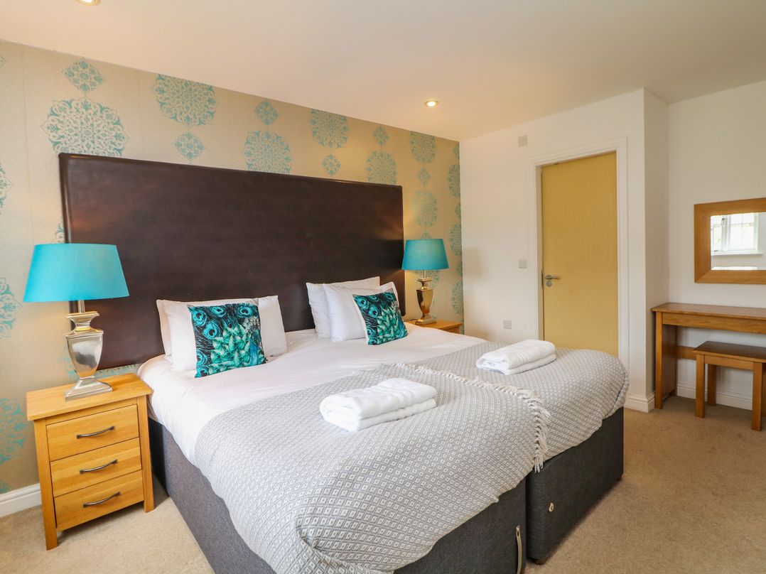 A bedroom with twin beds and a bedside table at Hartington near Two Dales
