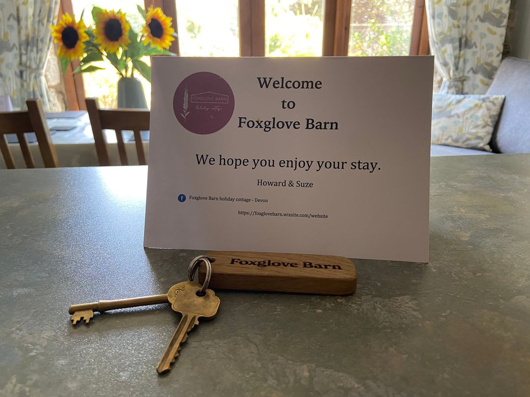 A welcome sign and keys on a table at Foxglove Barn in South Brent