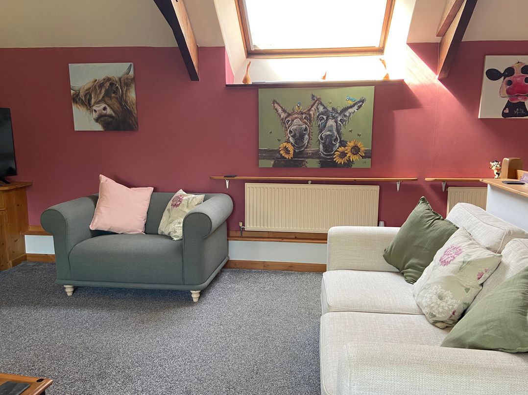 A living room with sofas and wall art at Foxglove Barn South Brent
