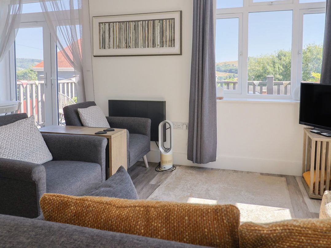 A living room with chairs and a table at Lyme Zest in Lyme Regis