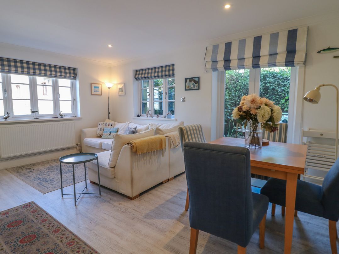 A living room with a sofa and dining area at November Cottage in Dittisham