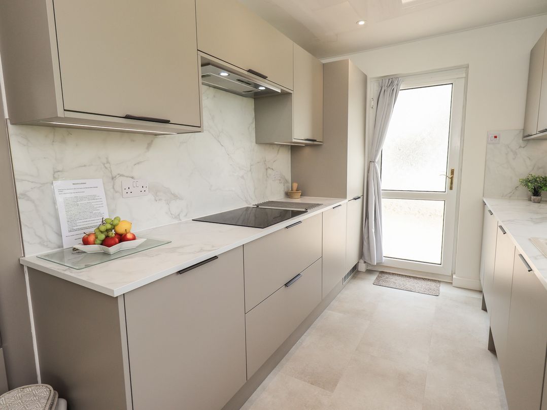 A kitchen with a cooking surface and cabinets at Oaklea in Keswick