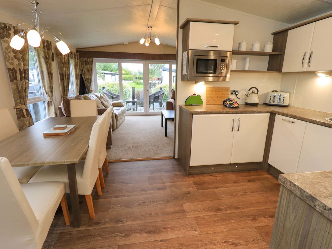 A kitchen and dining area with appliances and furniture at 41, Grandma's Cottage South Lakeland Leisure Village near Carnforth