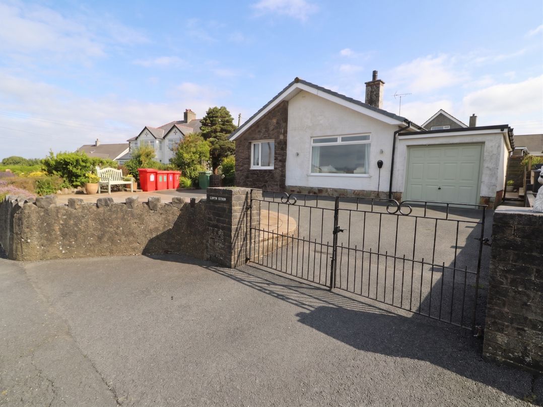 A house with a driveway and gate at Llwyn Eithin in Benllech