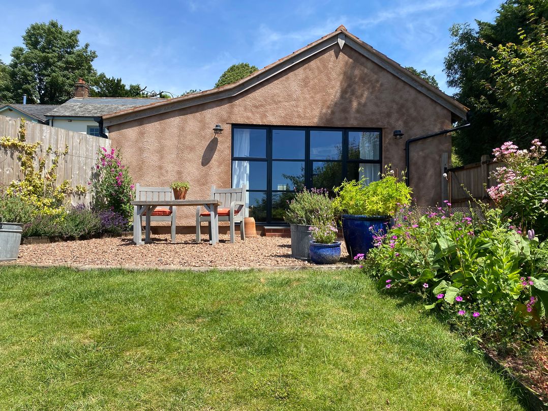 A house with a garden and seating area at Church Farm Dairy Cadbury near Thorverton