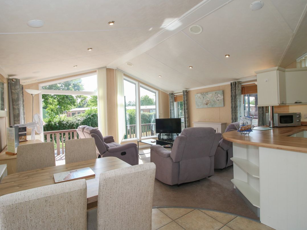 A living room with sofa and dining area at Daisy in Eardisland