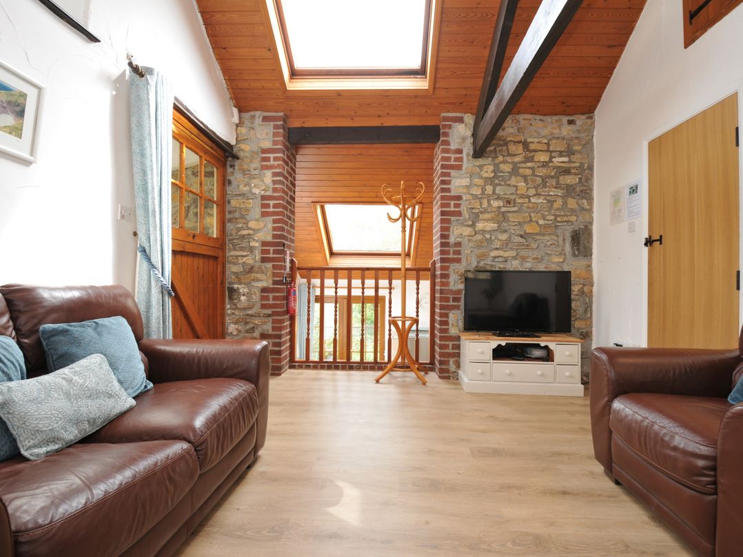 A living room with a sofa and television at Shipload Cottage in Hartland