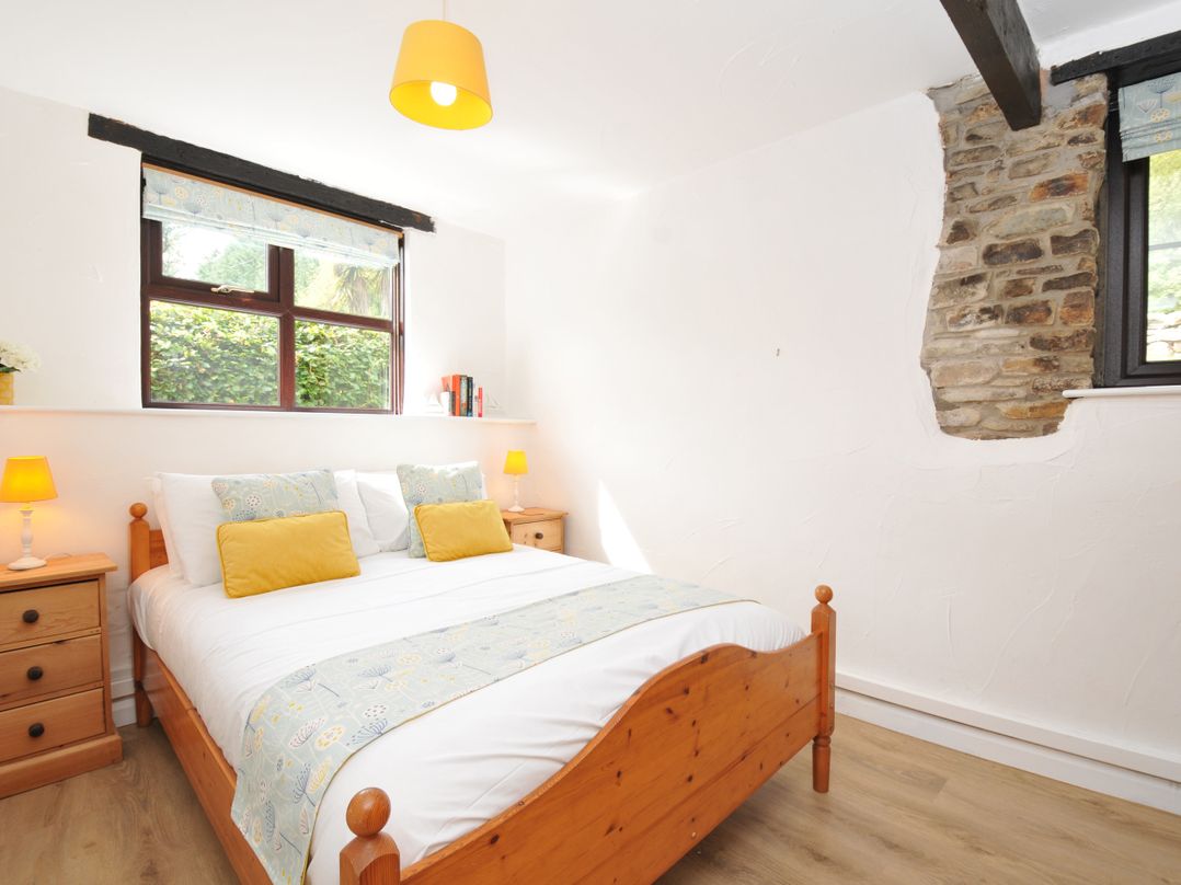 A bedroom with a bed and window at Shipload Cottage in Hartland