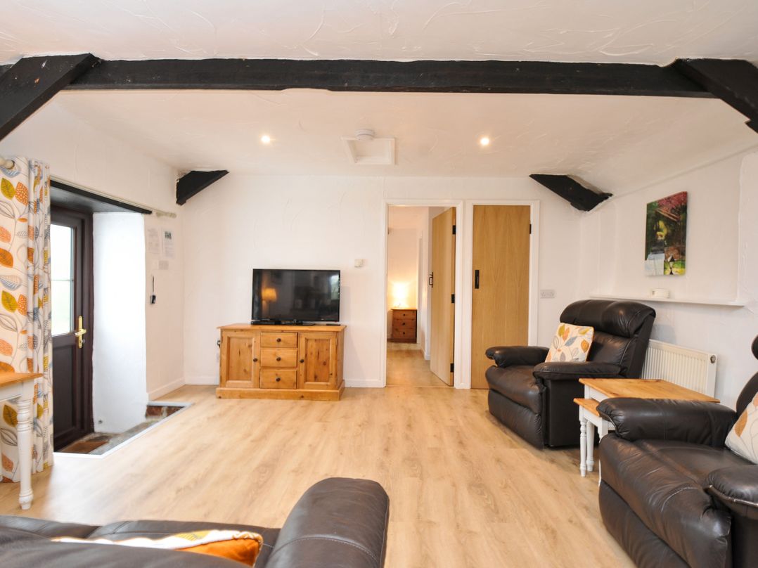 A living room with a sofa and television at Windbury Cottage Hartland