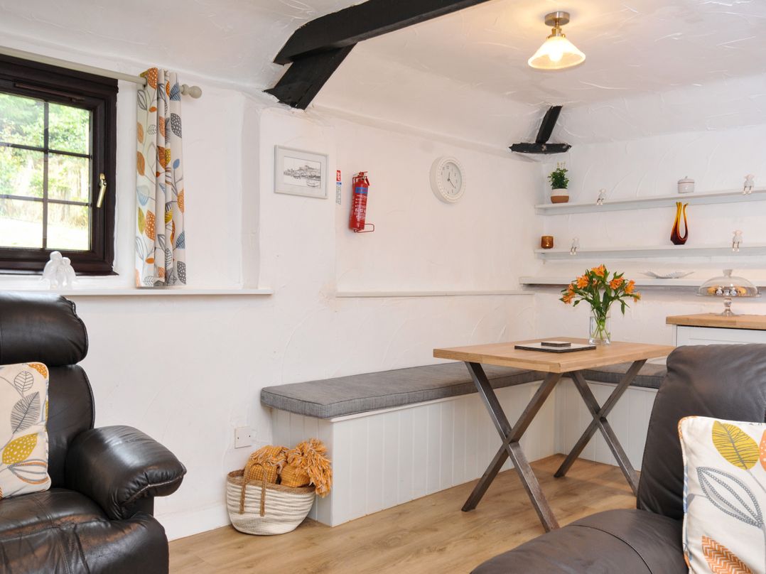 A seating area with a table and flowers at Windbury Cottage in Hartland