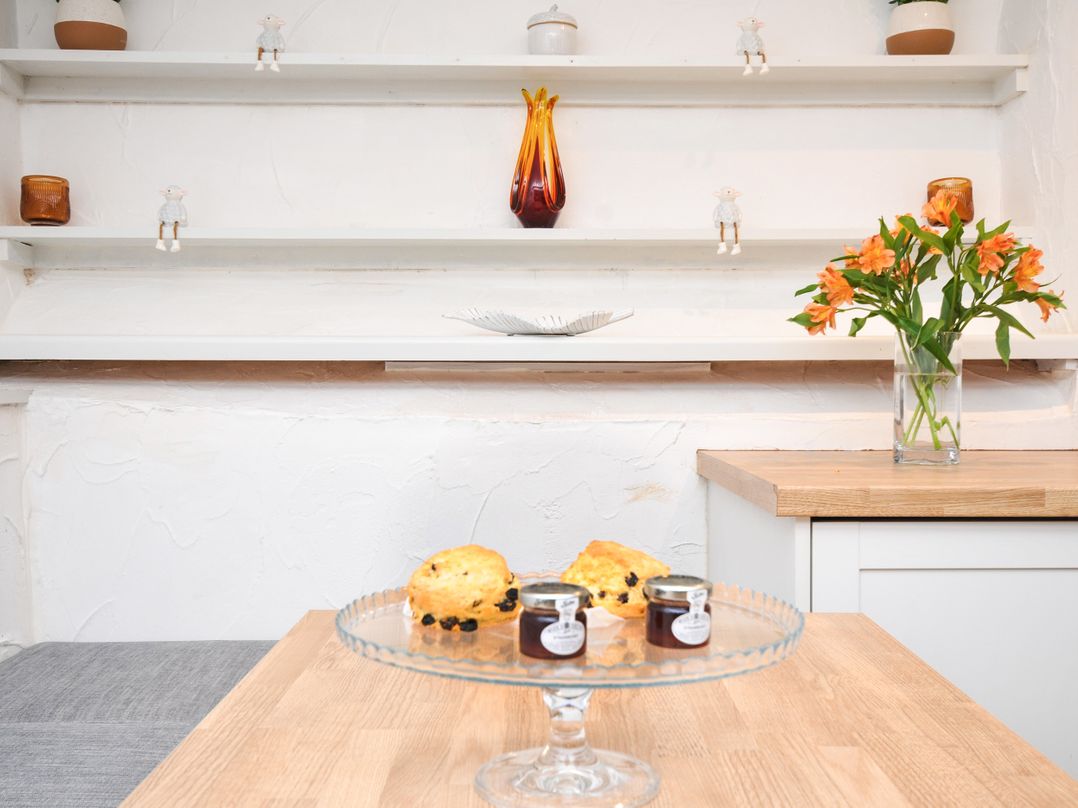 A kitchen with scones and jam on a table at Windbury Cottage in Hartland