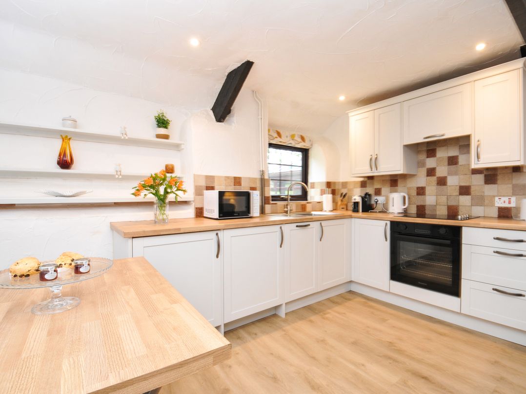 A kitchen with appliances and shelves at Windbury Cottage in Hartland