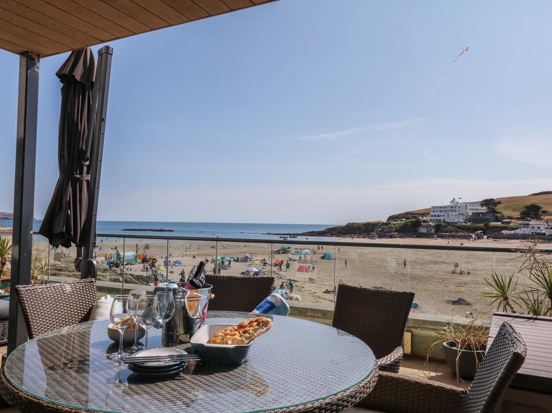 An outdoor dining area with a table and view of the beach at 4 Burgh Island Causeway in Bigbury
