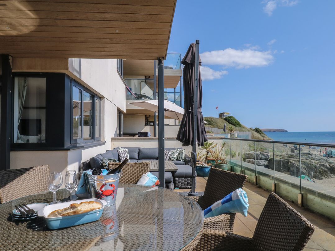 An outdoor seating area with a dining table and sofa at 4 Burgh Island Causeway Bigbury