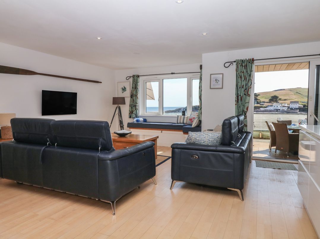 A living room with a sofa and television at 4 Burgh Island Causeway in Bigbury