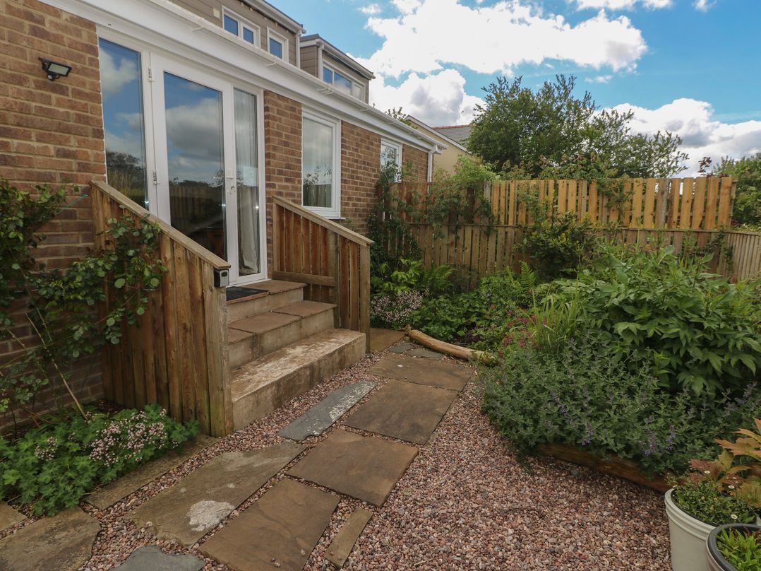 A garden with steps leading to a back door at Garden View in Pembroke
