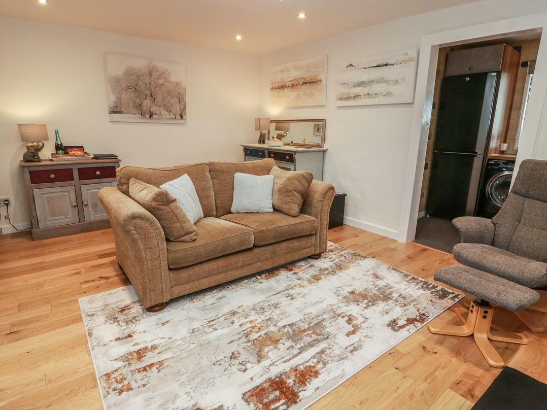 A living room with a sofa and artwork at Rosalin Cottage in Dreghorn near Irvine
