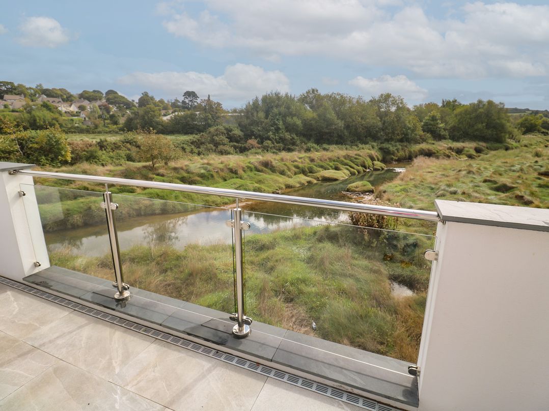 A balcony view overlooking a stream and vegetation at Carnon Gwel, Devoran