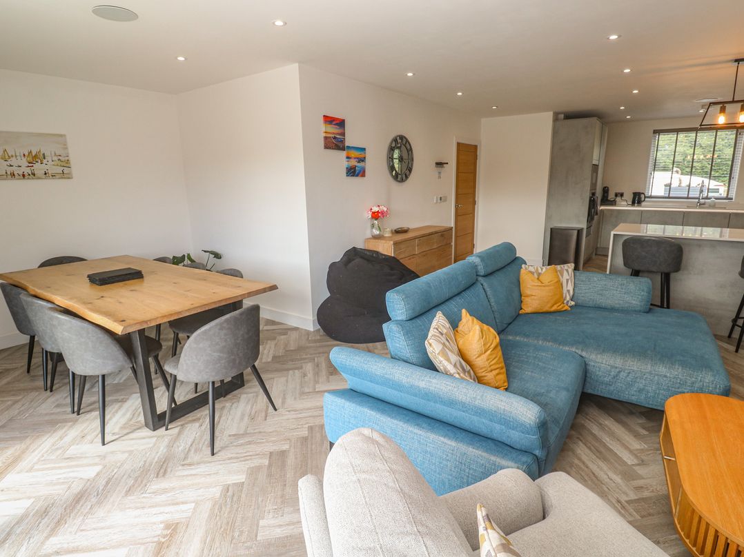 A living room with a sofa and dining area at Carnon Gwel, Devoran