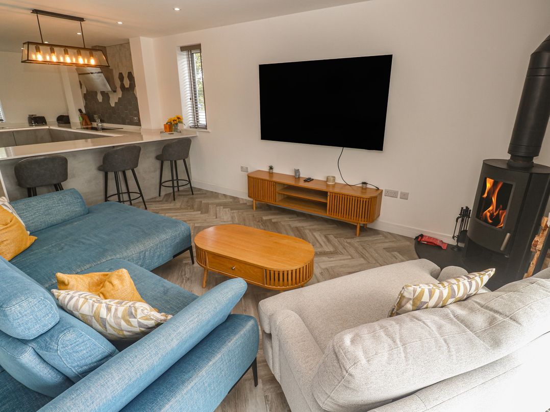 A living room with a sectional sofa and TV at Carnon Gwel, Devoran