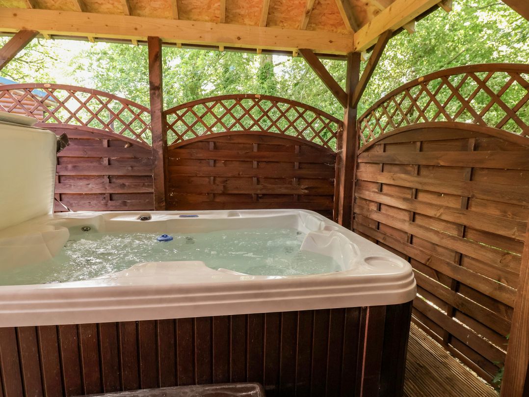 A hot tub enclosed by wooden panels at The Red in Llanerch Park near St Asaph