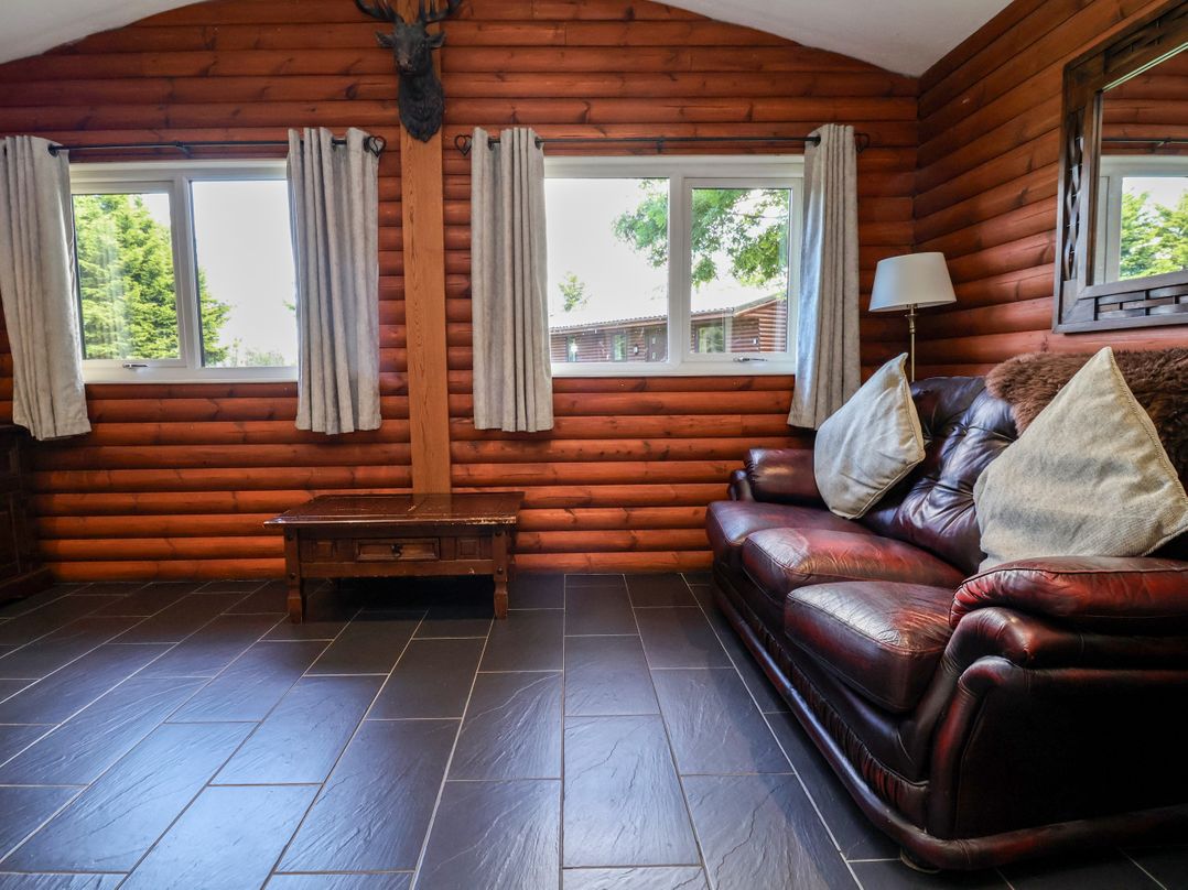 A living room with a sofa and windows at The Red in Llanerch Park near St Asaph
