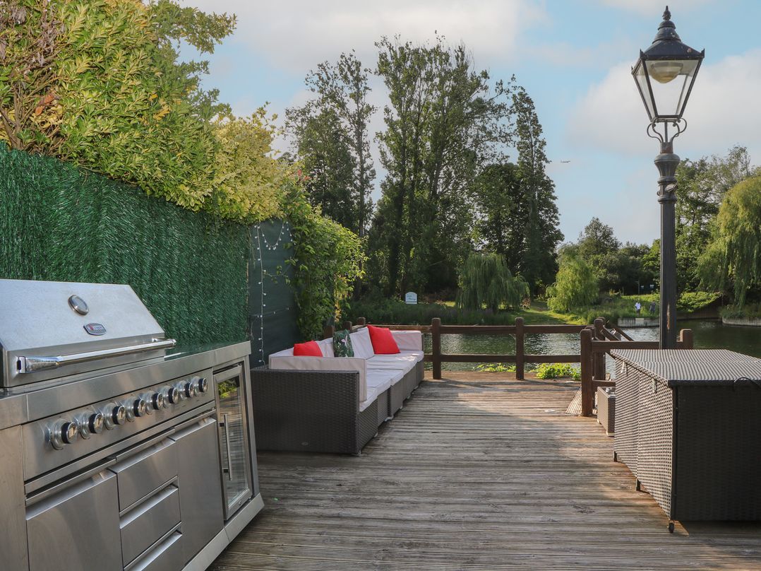 An outdoor area with a grill and seating at Coventina in Wraysbury