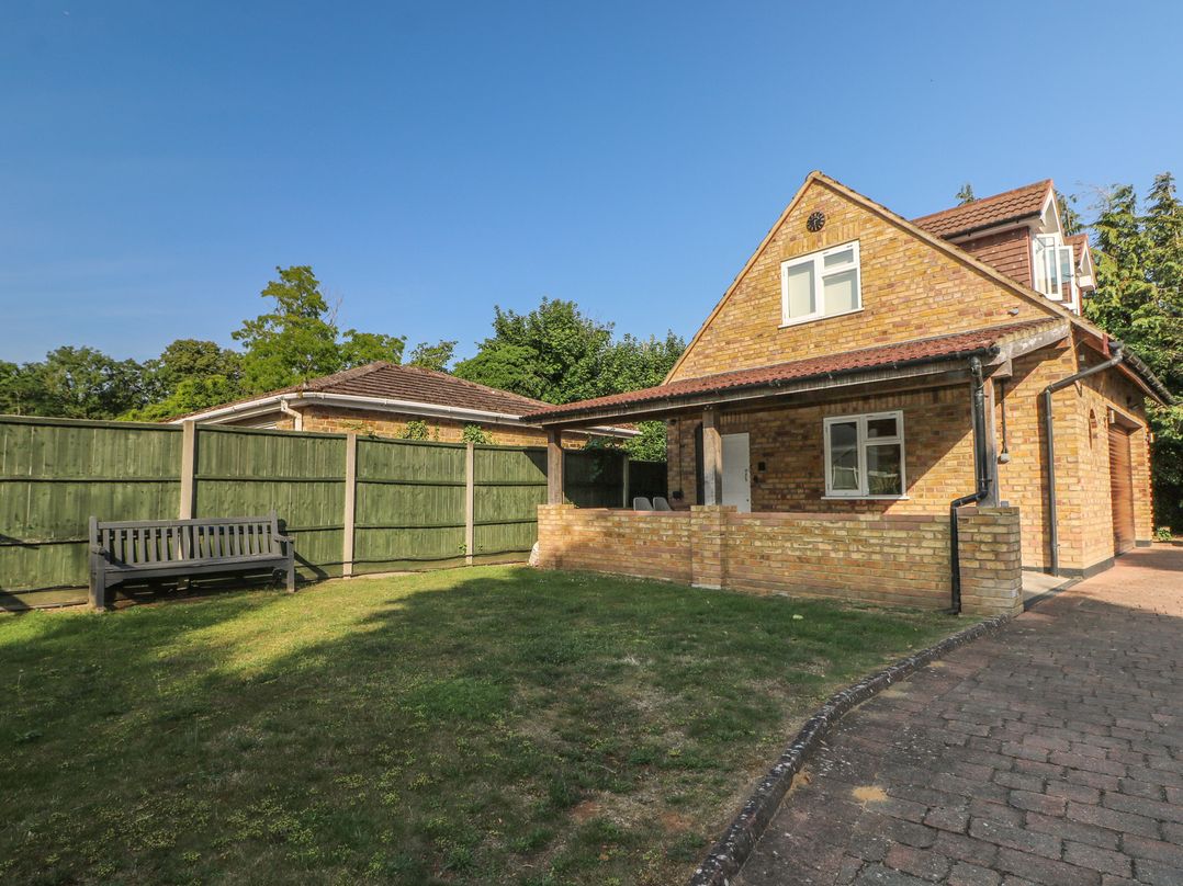 A house with a garden and a bench at Thames Retreat in Wraysbury