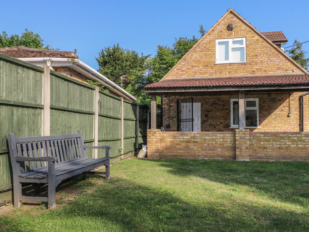 A house with a bench and a fence at Thames Retreat in Wraysbury