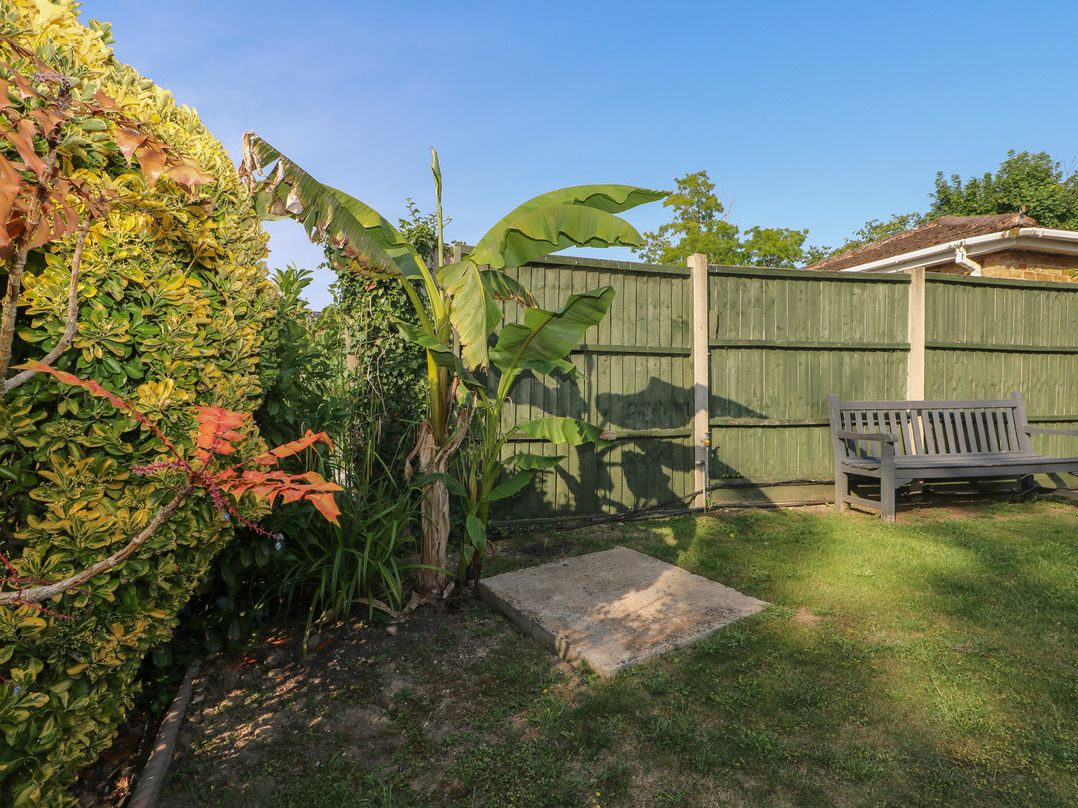 A garden with a bench and plants at Thames Retreat in Wraysbury