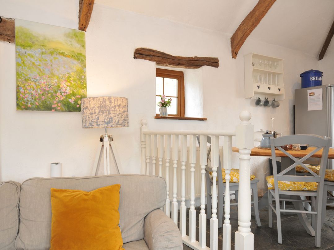A living room with a sofa and dining area at Skiber Long in Bray Shop near Launceston