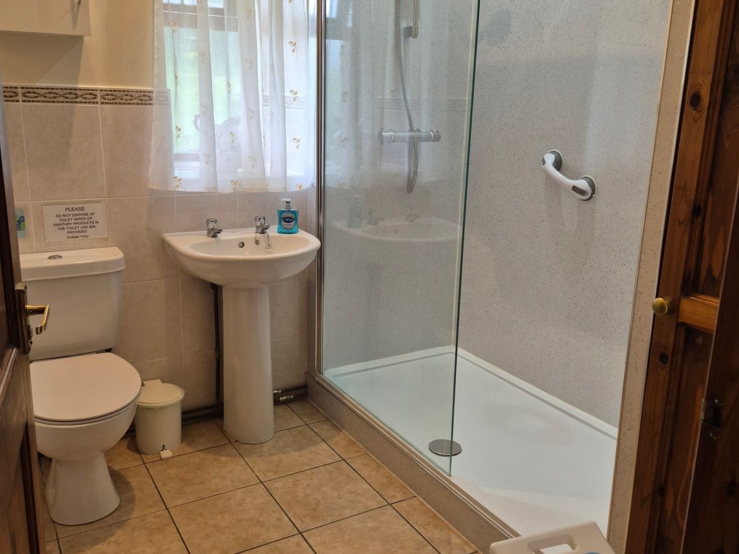 A bathroom with a shower, sink, and toilet at The Carthouse in Woolhope