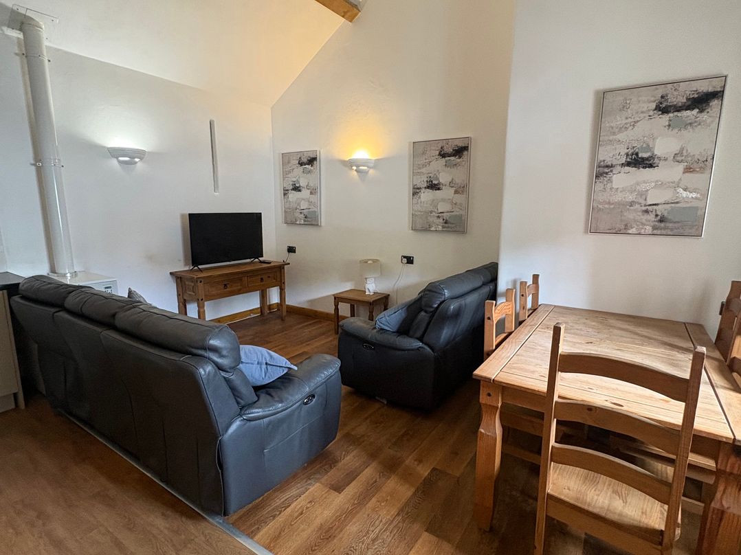 A living room with a sofa and a table at Woodside Cottage in Kerry