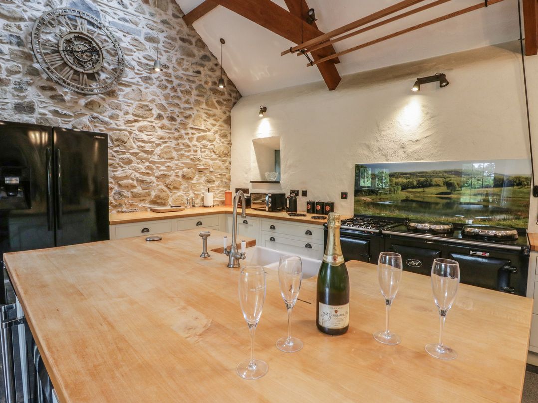 A kitchen with a wooden island and appliances at St Dogwells Barn near Wolfscastle