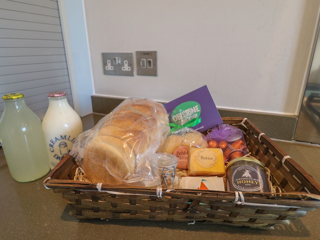 A basket with bread, butter, honey, milk, and lemonade at 22 Dart Marina Dartmouth