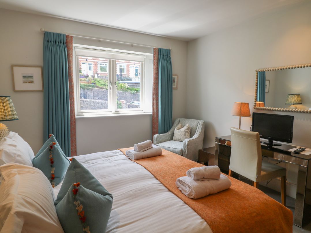 A bedroom with a bed, desk, and chair at 22 Dart Marina, Dartmouth