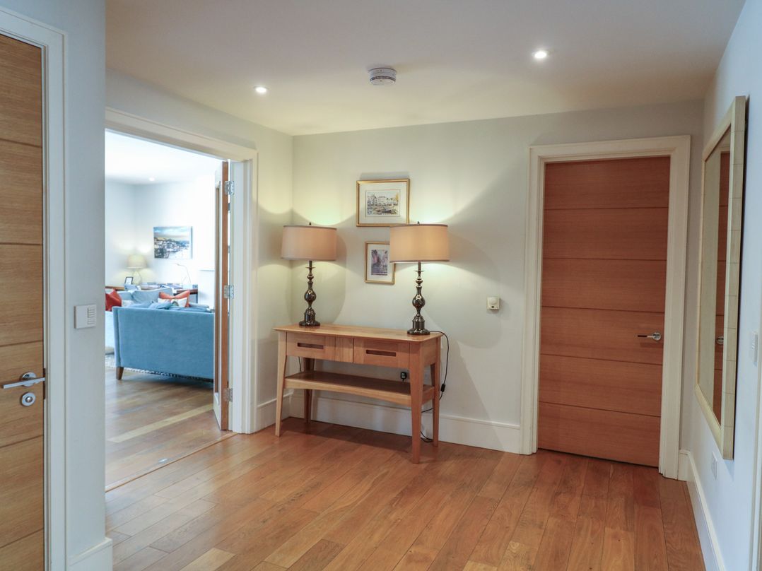A hallway with a console table and lamp at 22 Dart Marina in Dartmouth